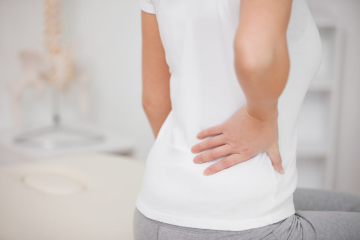 Почему после кесарева сечения может болеть спина, как избавиться от боли?